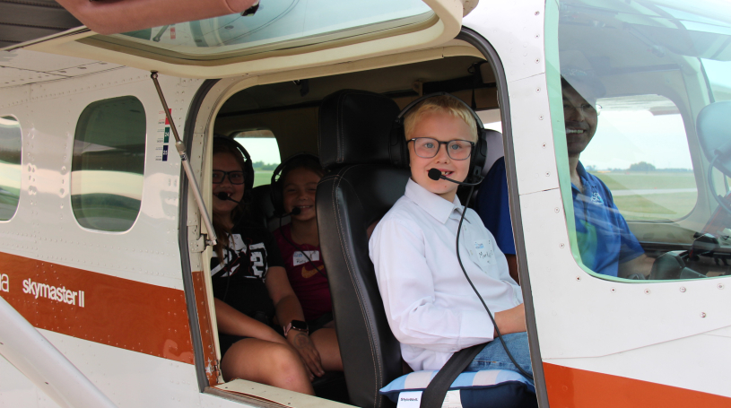 Photo of children going for a ride in an airplane at a Discover Aviation event.