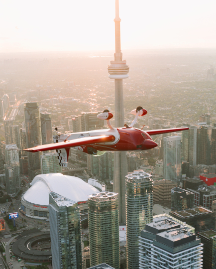 Photo of Luke Penner flying inverted in front of Toronto's CN Tower and the Rogers Centre